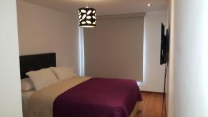 1 dormitorio con 1 cama y luz colgante en Miraflores 820, en Lima