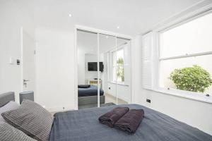 a white bedroom with a bed and a window at Bright Luxurious Flat in Little Venice in London