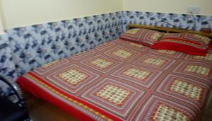 a bed with a quilt and two pillows on it at Hotel Regal Palace in Chittagong