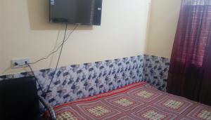 a bedroom with a bed and a tv on the wall at Hotel Regal Palace in Chittagong