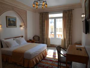 una camera d'albergo con un letto, una scrivania e una finestra di Dar Nador a Nador