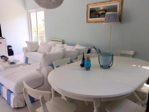 a living room with a white table and a white couch at Buellis House in Fregene