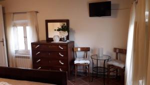 a bedroom with a dresser and a mirror and chairs at Ai Bastiani in Capannori