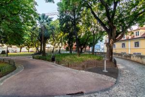 een weg in een park met bomen en een hek bij The Explorer's Home | Sunny. Central. Free Parking in Lissabon