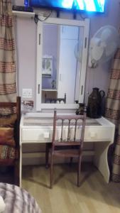 a table with a mirror and a chair in a room at LekkeRus Guest House in Vereeniging