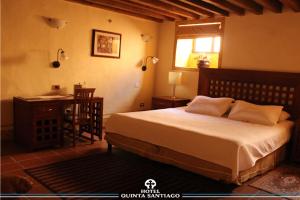 A bed or beds in a room at Hotel Quinta Santiago