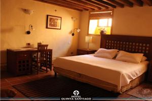 a bedroom with a bed and a desk and a desk at Hotel Quinta Santiago in Querétaro