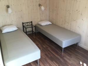 2 Betten in einem Zimmer mit Holzböden in der Unterkunft Holiday Home near Norrköping in Skärblacka