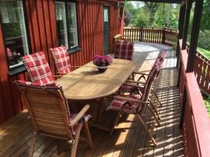 einen Holztisch und Stühle auf einer Terrasse in der Unterkunft Holiday Home near Norrköping in Skärblacka