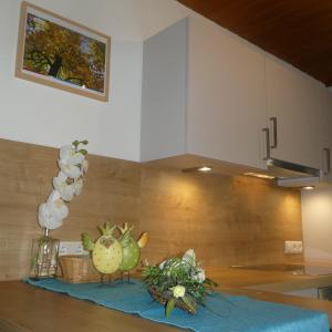 eine Küche mit einer Theke und einem Tisch mit Blumen in der Unterkunft Appartements Pfausler in Oetz