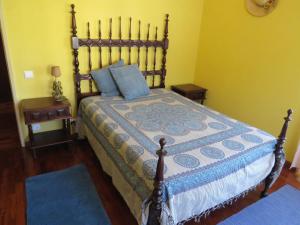 una camera da letto con un grande letto con cuscini blu di Casa São João a São João da Serra