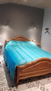 a large wooden bed in a bedroom with blue sheets at Maison Centre Ville Parking privé in Ax-les-Thermes