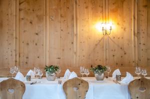 uma sala de jantar com uma mesa com copos de vinho em Hotel Veduta em Cinuos-Chel