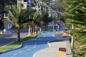 馬卡埃的住宿－皇家馬卡埃皇宮酒店，骑着自行车沿着棕榈树的街道骑行的人