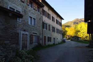 an old stone building on a street next to a road at Fattoria La Guedrara in Sestola