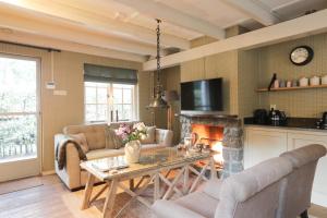 a living room with a table and a fireplace at Lindenhof in Garderen
