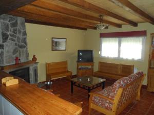 sala de estar con sofá y chimenea en La Puente 10 de Gredos, en Hoyos del Espino