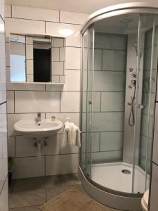 a bathroom with a shower and a sink and a mirror at Gästehaus Blümel in Köflach