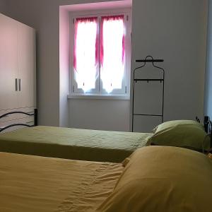 1 dormitorio con 2 camas y una ventana con cortinas rojas en Bed &Breakfast Bellavista, en San Giovanni Bianco