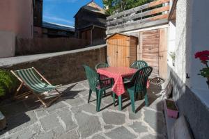 un patio con mesa, sillas y una valla en Chez Bernard & Chantal, en Peisey-Nancroix