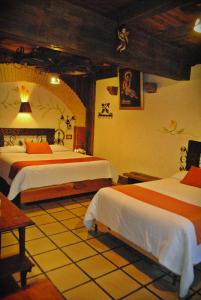 a bedroom with two beds in a room at Hotel Hacienda Don Juan in San Cristóbal de Las Casas