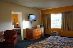 a hotel room with a bedroom with a bed and a television at Classic Inn in Red Bluff