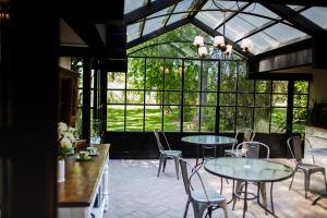 a conservatory with two tables and chairs and windows at La Matera Posada de Campo in San Rafael