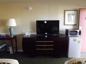 a living room with a flat screen tv on a dresser at Sage Motel in Vernal