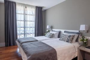 a bedroom with a large bed and a large window at Hotel The Park Derio in Derio