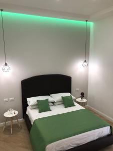 - une chambre avec un lit vert et blanc et 2 tables dans l'établissement DOMO B&B, à Naples