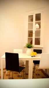 a white dining room table with chairs and a white cabinet at WW Hostel & Suites in Coimbra