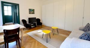 un soggiorno con divano, tavolo e sedie di Quiet & Green, With Terrace a Vienna