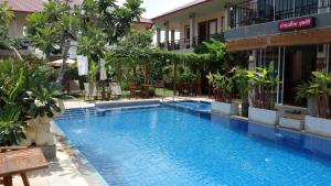 a swimming pool in front of a building at Baan Sooksiri Bangsaray in Bang Sare