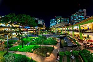 una città di notte con persone che passeggiano per un parco di Mabolo Garden Flat a1 Rooftop Pool Near Ayala Mall a Cebu City