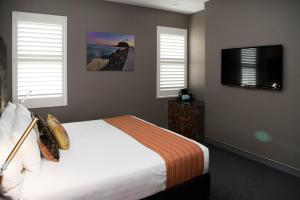 a bedroom with a bed and a flat screen tv at Junction Hotel in Newcastle
