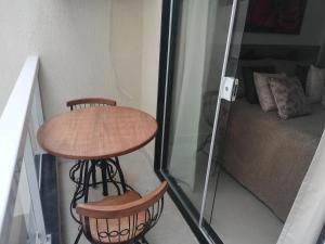 een kleine tafel en twee stoelen naast een bed bij Flats Dunas Cabo Frio in Cabo Frio