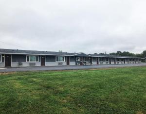 a building with a grass field in front of it at Neva Jean Motel in Marshfield