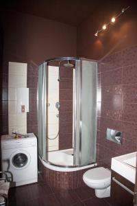 a bathroom with a shower and a washing machine at Sweet Kato Apartment in Katowice