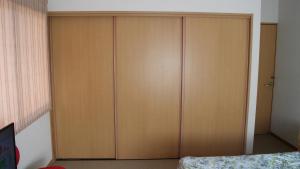 糸島市にあるサウス ウィンド シャレーのベッド付きの客室内の大きな木製キャビネット