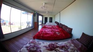 a large bed in a room with large windows at ไร่กะหล่ำหวาน ภูทับเบิก in Ban Phu Pun