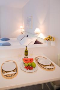林都斯的住宿－威樂迪林德斯酒店，一张桌子,上面放着一瓶葡萄酒和一盘水果