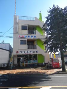 a building with a store on the side of a street at Minshuku Iwakawa in Yakushima