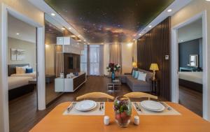 a room with a dining table and a bedroom at HAIAN Beach Hotel & Spa in Danang