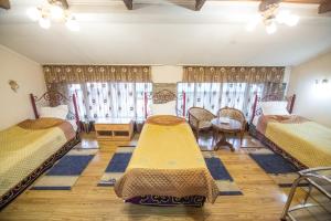 een kamer met drie bedden en een tafel en stoelen bij Eco House in Osh