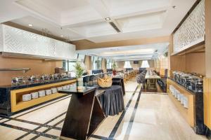 a dining room with tables and counters in a restaurant at Royal Kuningan Hotel in Jakarta