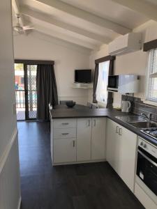 a kitchen with white cabinets and a counter top at Geelong Surfcoast Hwy Holiday Park in Mount Duneed