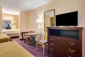 a hotel room with a flat screen tv and a bedroom at Motel 6-Macon, GA in Macon