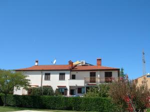 een groot wit huis met een rood dak bij Apartments Nadija in Rovinj