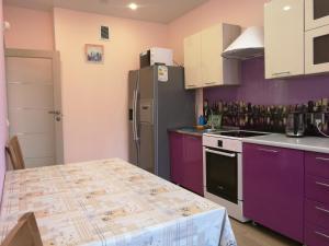イルクーツクにあるАпартаменты на Карла Либкнехта 114のキッチン(紫色のキャビネット、冷蔵庫付)