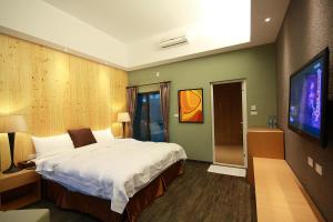 una camera da letto con un letto grande e una TV a schermo piatto di Great Nature Villa a Jiji